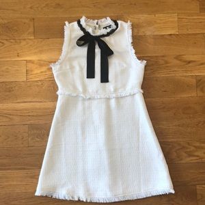 White dress with frey detail and black neck tie